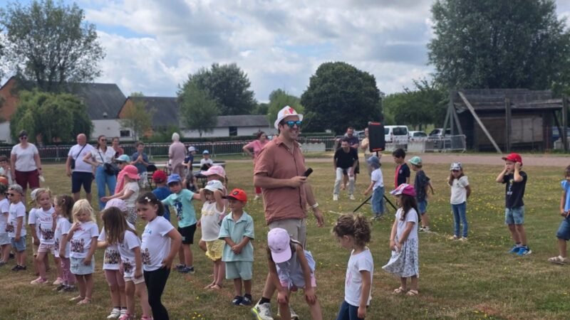 Les enfants des ecoles rassembles sur le stade lors de la kermesse de fin d'annee.