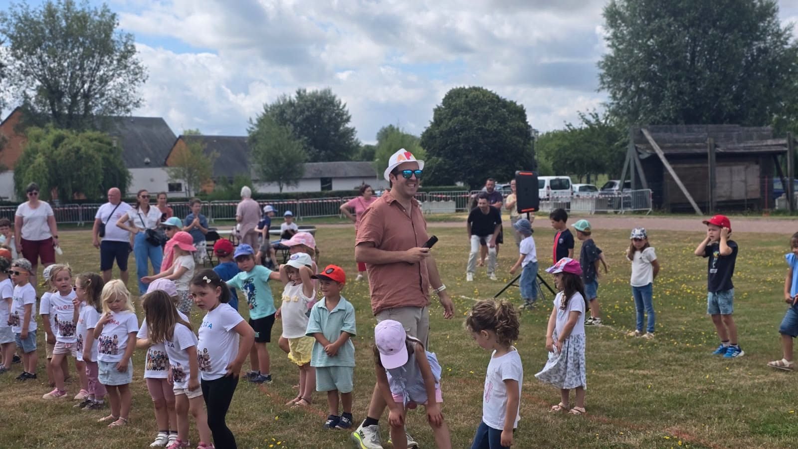 Les enfants des ecoles rassembles sur le stade lors de la kermesse de fin d'annee.