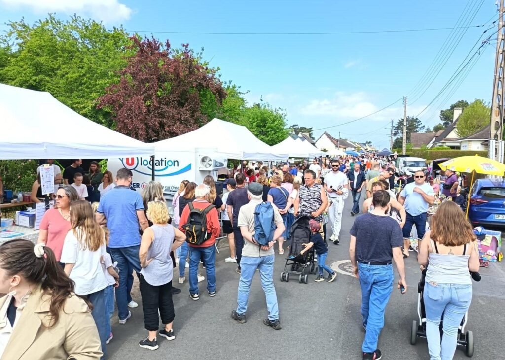La foule parcourt le boulevard Kennedy entre les stands de la foire aux greniers de Merville-Franceville.